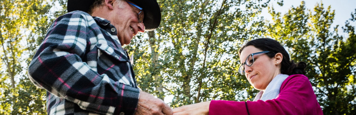 Senior jouant à la pétanque, accompagné d'une aidante