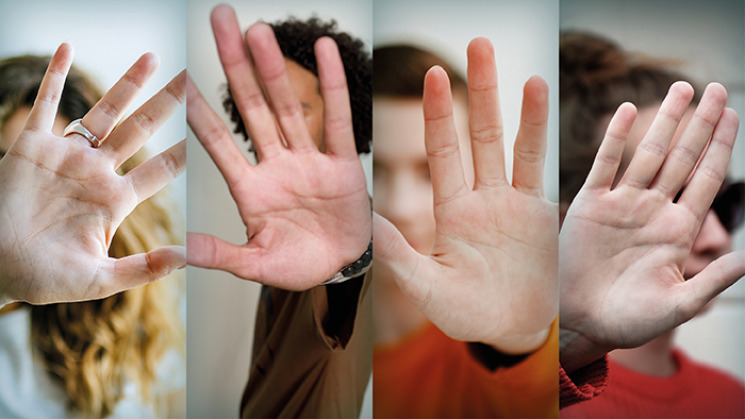 Photographie de quatre personnes faisant barrage avec leur main